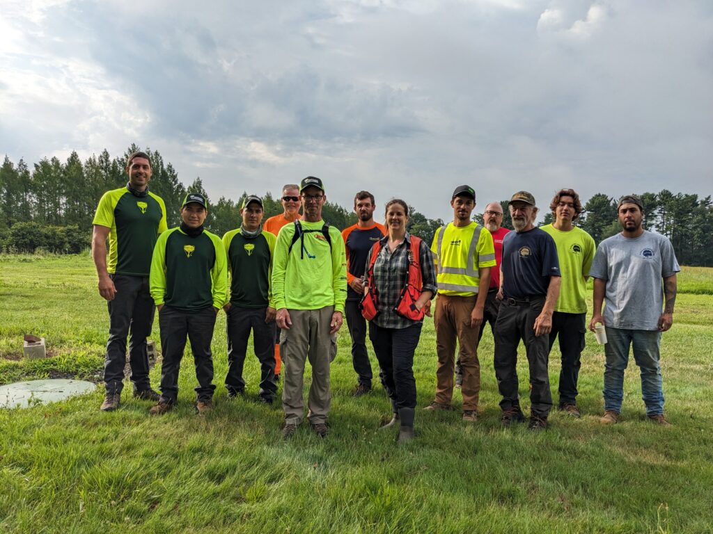 group of people standing in a field smiling at the camera